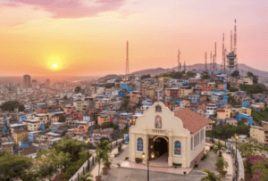 Hilltop chapel overlooking colorful hillside homes in Guayaquil, Ecuador at sunset